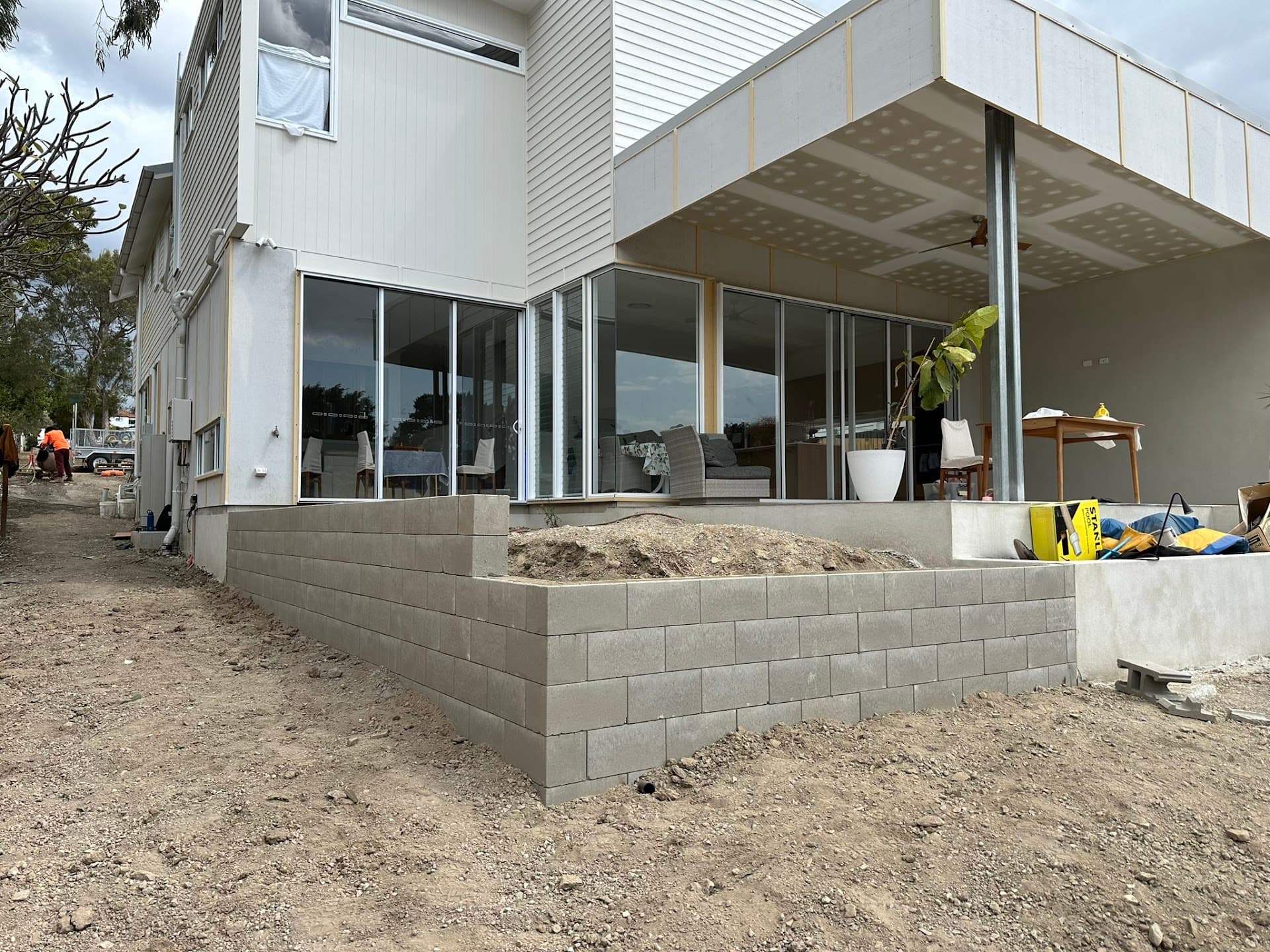 Besser block retaining wall built beneath a patio at a two-storey home