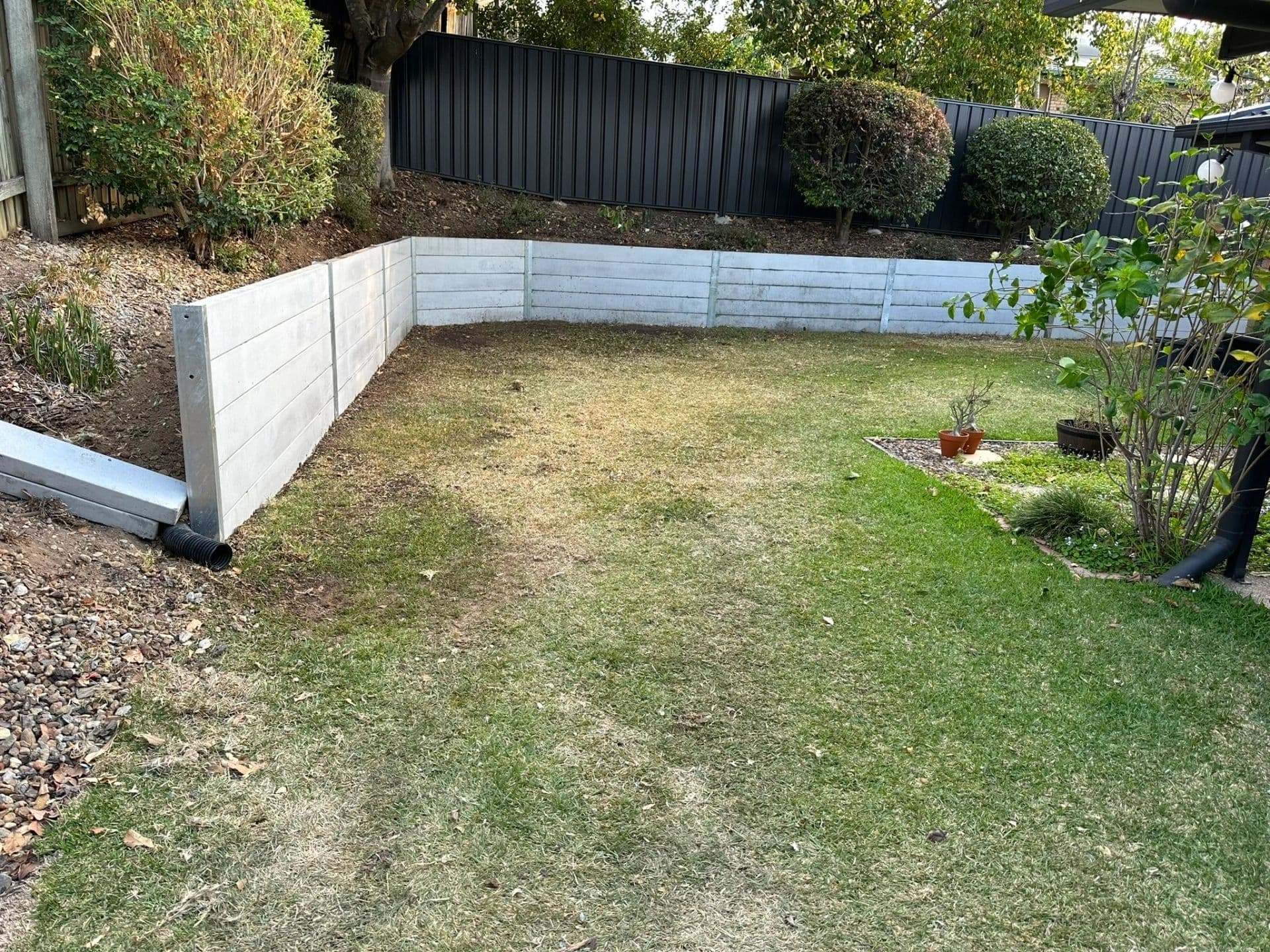 New concrete sleeper retaining wall in a backyard ready for new turf